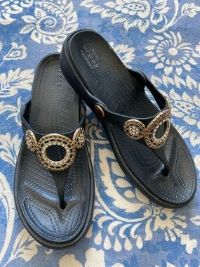 CROCS Black Thong Sandals with Gold Medallion Accents size 7